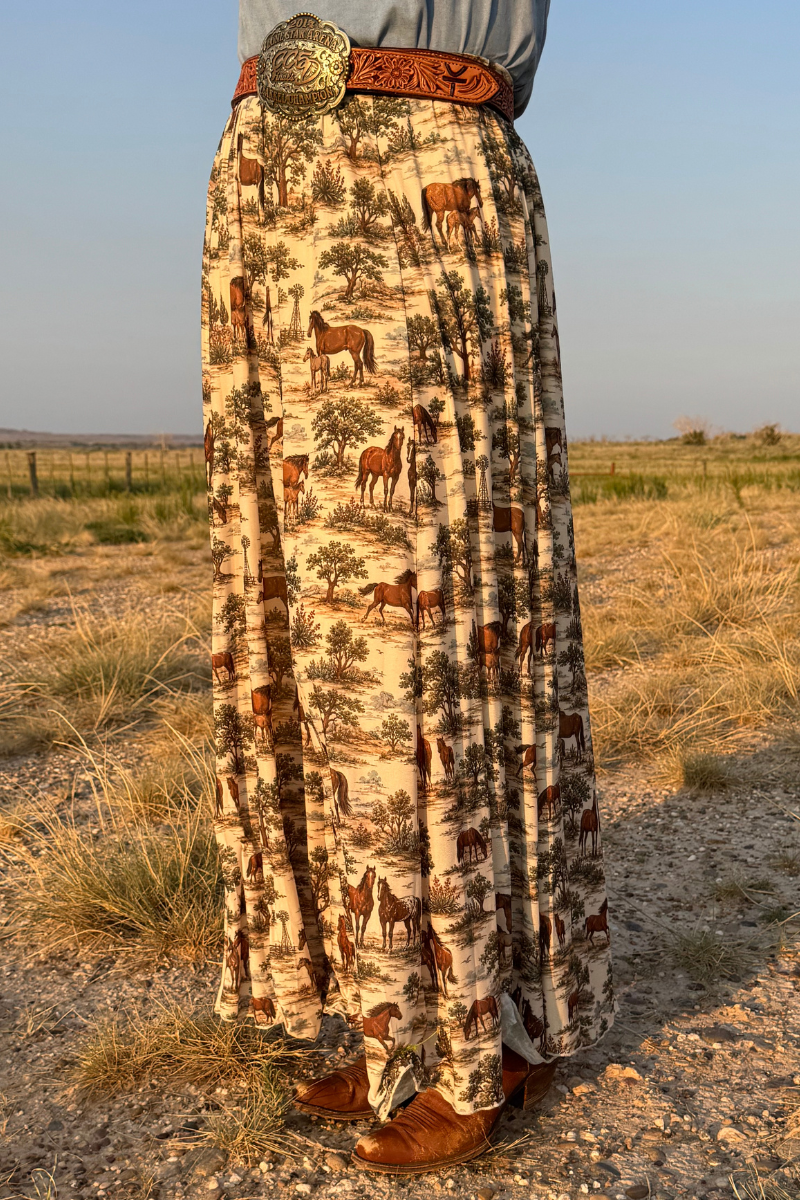 Tan maxi skirt with safari-style animal print and wide gold buckle belt at waist