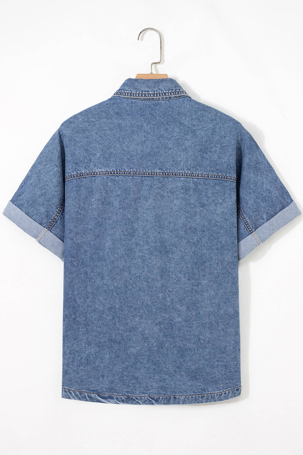 Blue denim short sleeve button-up shirt back view with yoke seam and stitched hem
